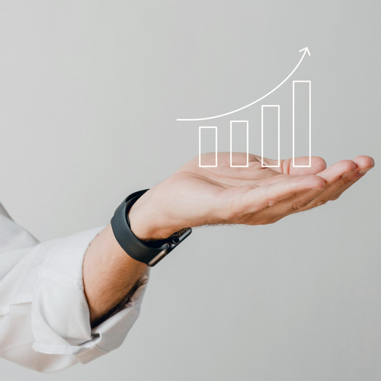 Photo of a hand of a man holding an upward trending bar chart.