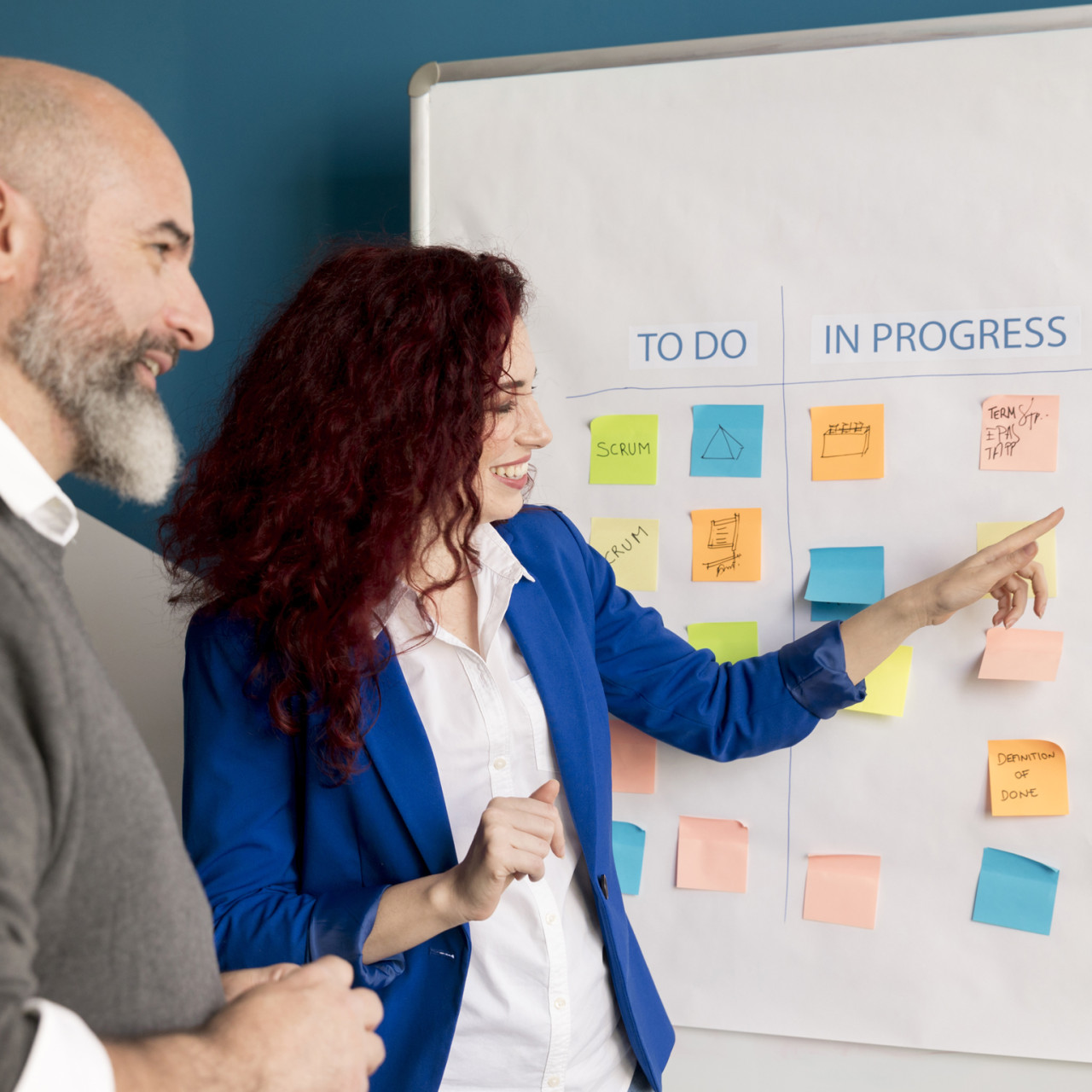 Photo of a man and woman doing development planning on a kanban board.