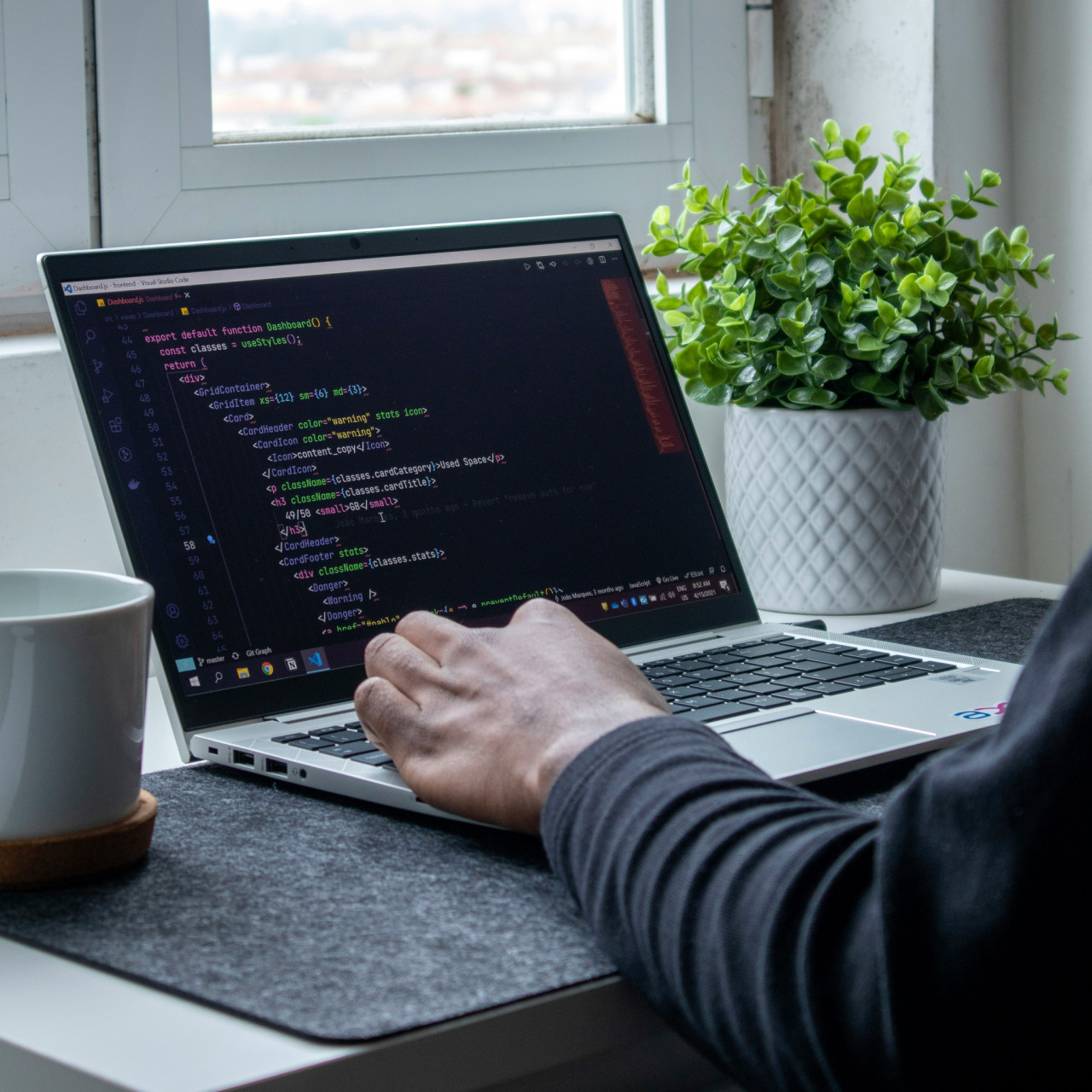 Photo of a man coding on his laptop.