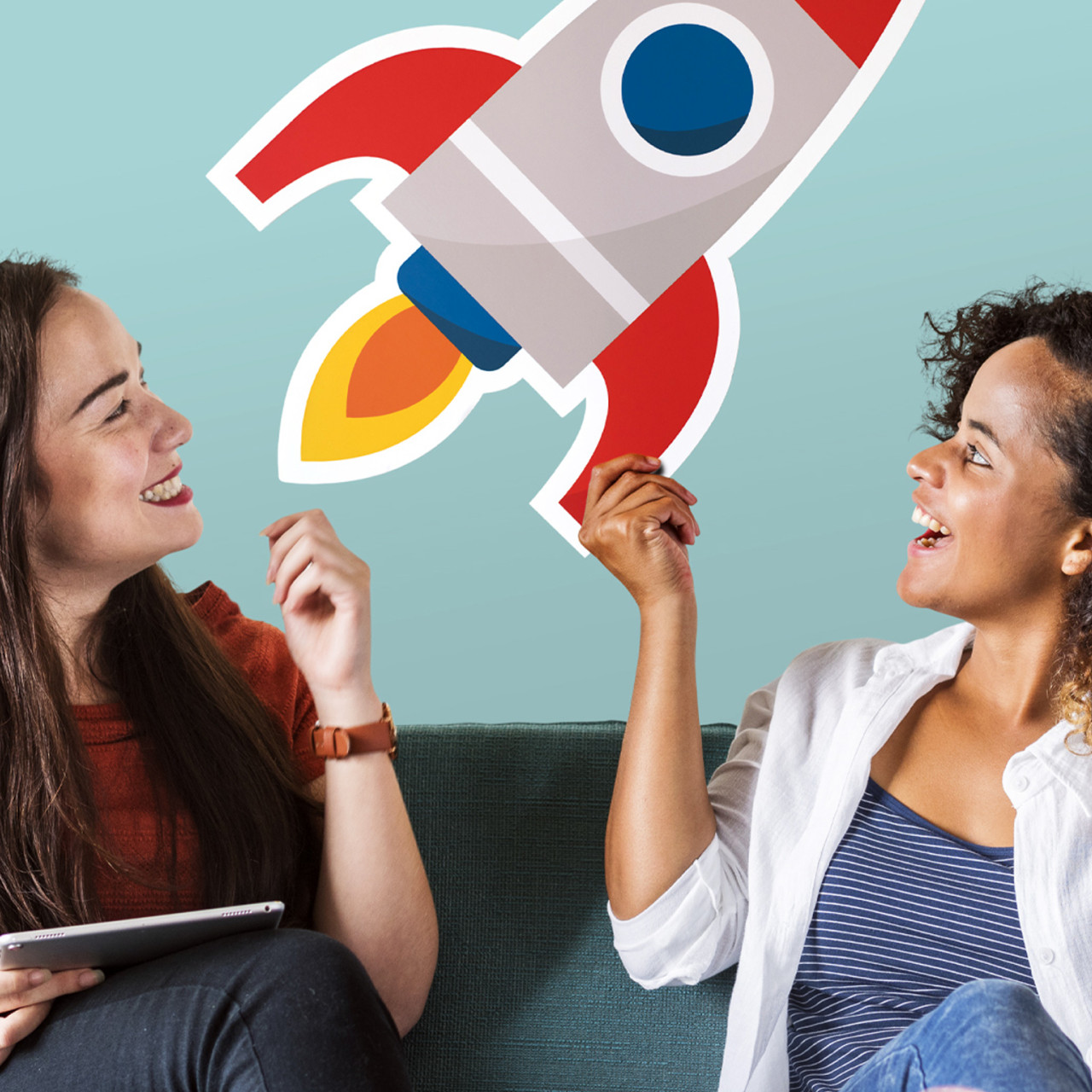 Photo of women holding a cardboard cut out of a rocket flying.